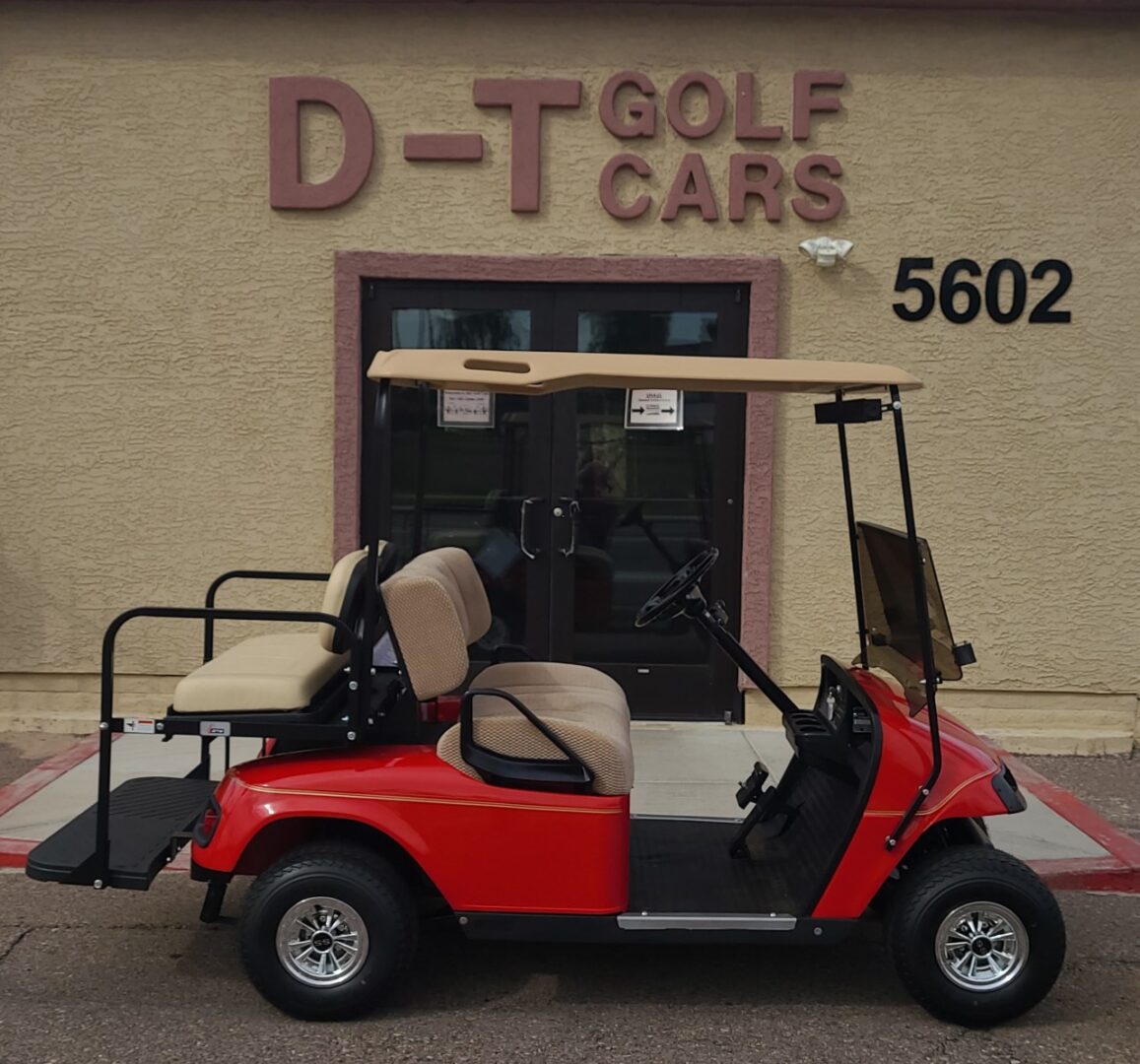 A red golf cart parked in front of a building.