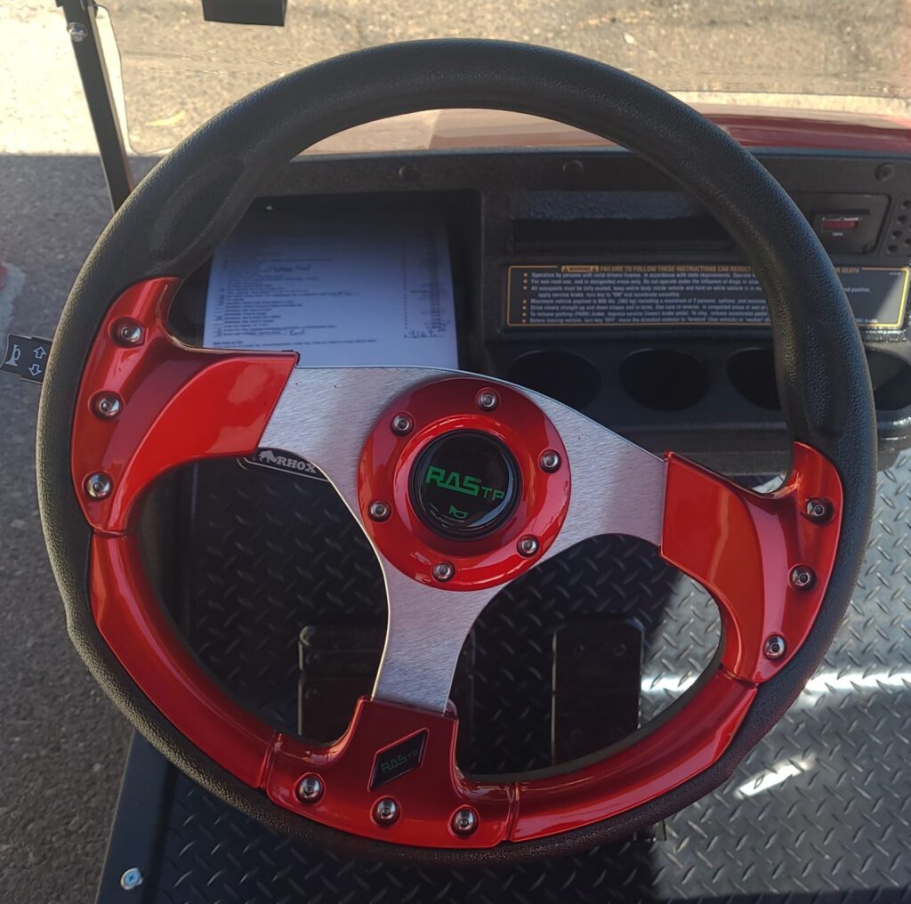 A steering wheel with red and white accents.