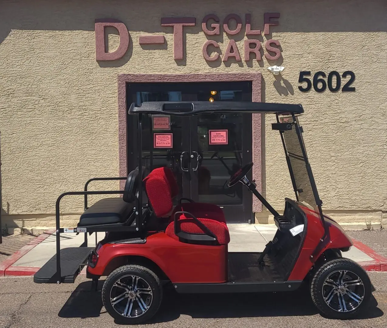 A red golf cart parked in front of a building.