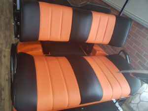 A black and orange seat with two rows of seats.