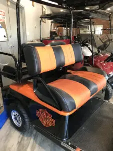 A golf cart with two seats in the back.
