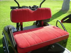 A red golf cart seat with the back of it.