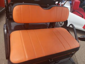 A seat with orange leather on it