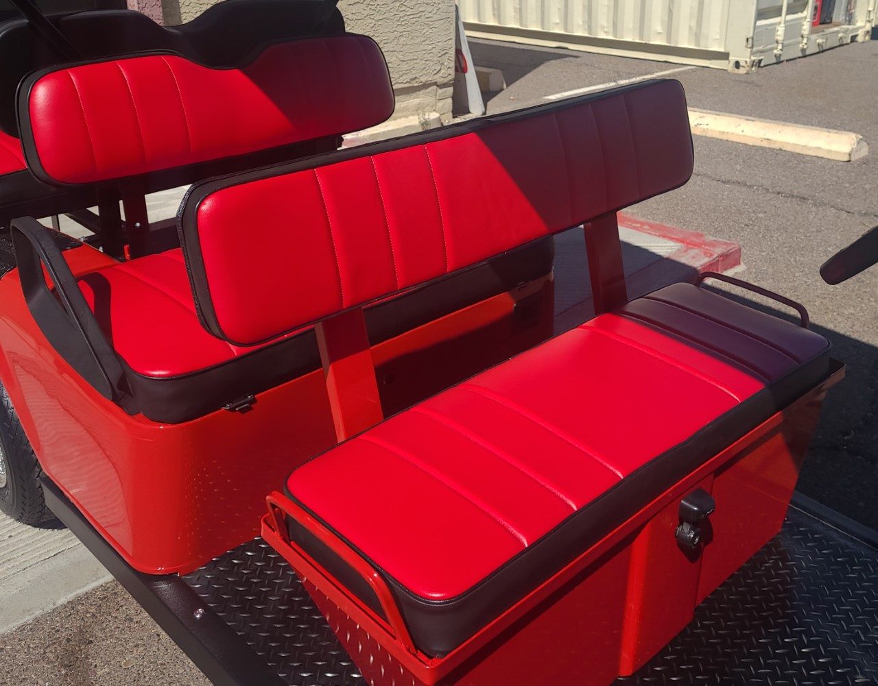 A red and black seat on the back of a truck.