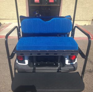 A blue seat on the back of an electric cart.