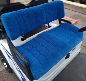 A blue seat cover on the back of an electric cart.