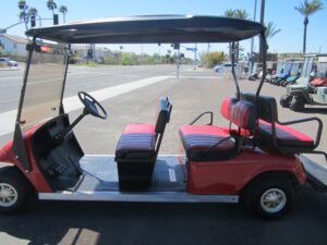 A red golf cart is parked on the street.
