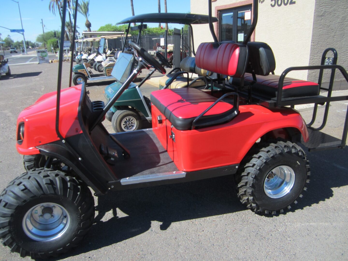 Red off-road golf cart with large tires